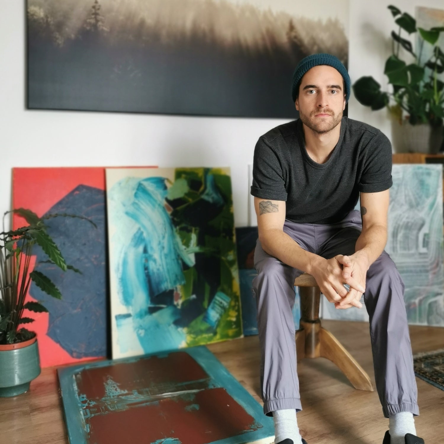 Promotional picture of the artist Max Lanzinger in front of some of his paintings.