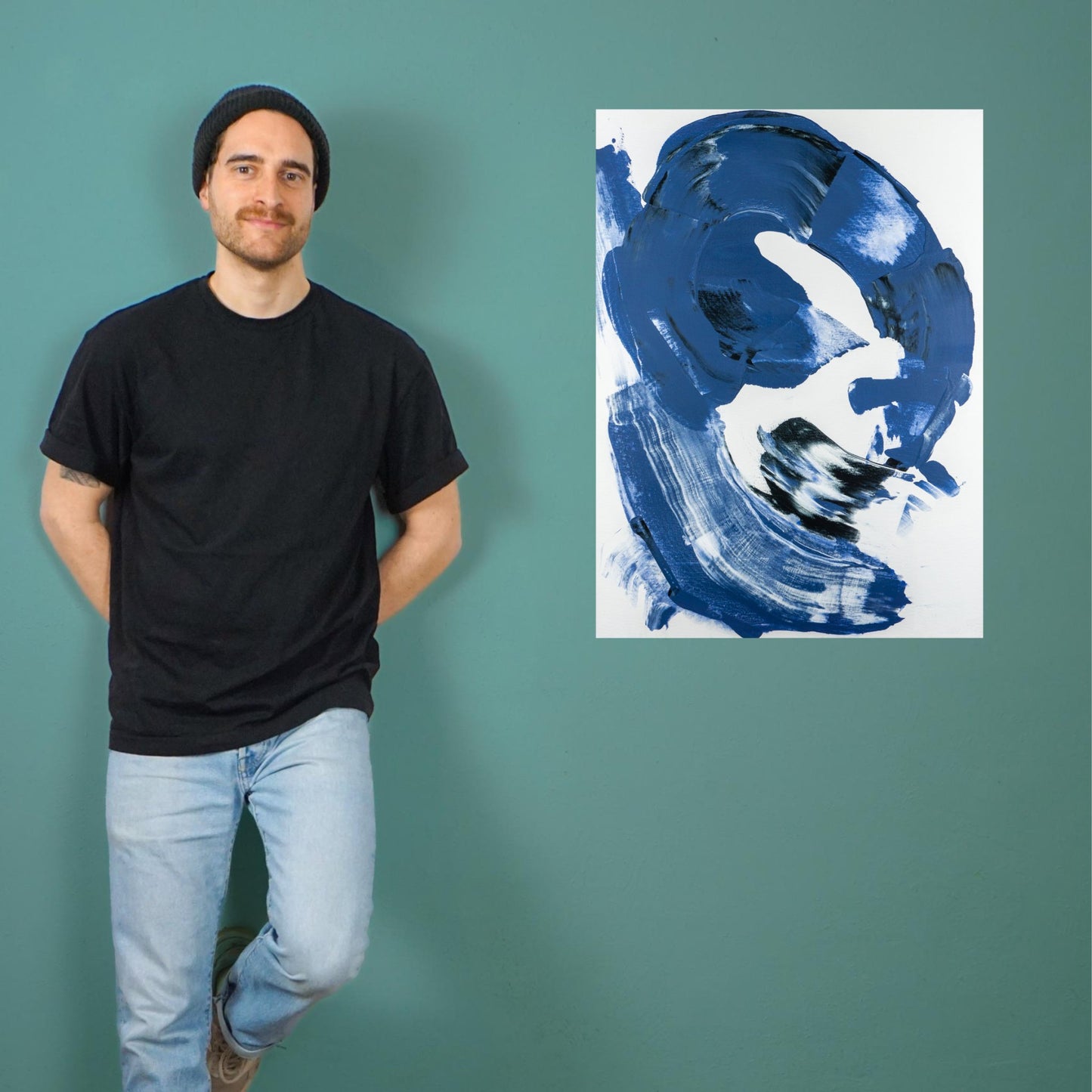 Max Lanzinger standing next to fine art print with blue abstract shape.