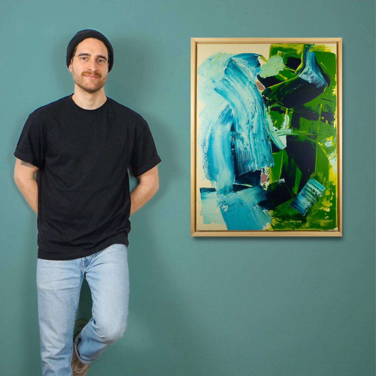 Max Lanzinger standing next to an original acrylic painting in his studio in Vienna.