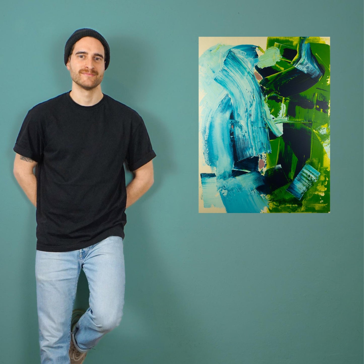 Max Lanzinger standing next to one of his acrylic paintings in his studio.